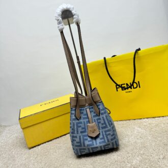Medium-sized Origami handbag, imitation denim light blue fabric material, decorated with FF pattern. This style is designed with a deformable and innovative design to highlight the double-sidedness and creativity of FENDI: it is equipped with a flexible mechanism composed of 8 magnetic buckles, which can be folded into an origami-style bucket bag. When the magnets are all attracted to the magnetic buckle in the middle, gently pull the leather tie on the short shoulder straps on both sides and turn into a tote bag. It comes with a key ring hanger with metal FENDI lettering and beige leather details. Lined interior compartment with gold finish metal piece. Leather dual handle design for hand or shoulder. Size: 15×15×18.5cm Model: 9918 denim