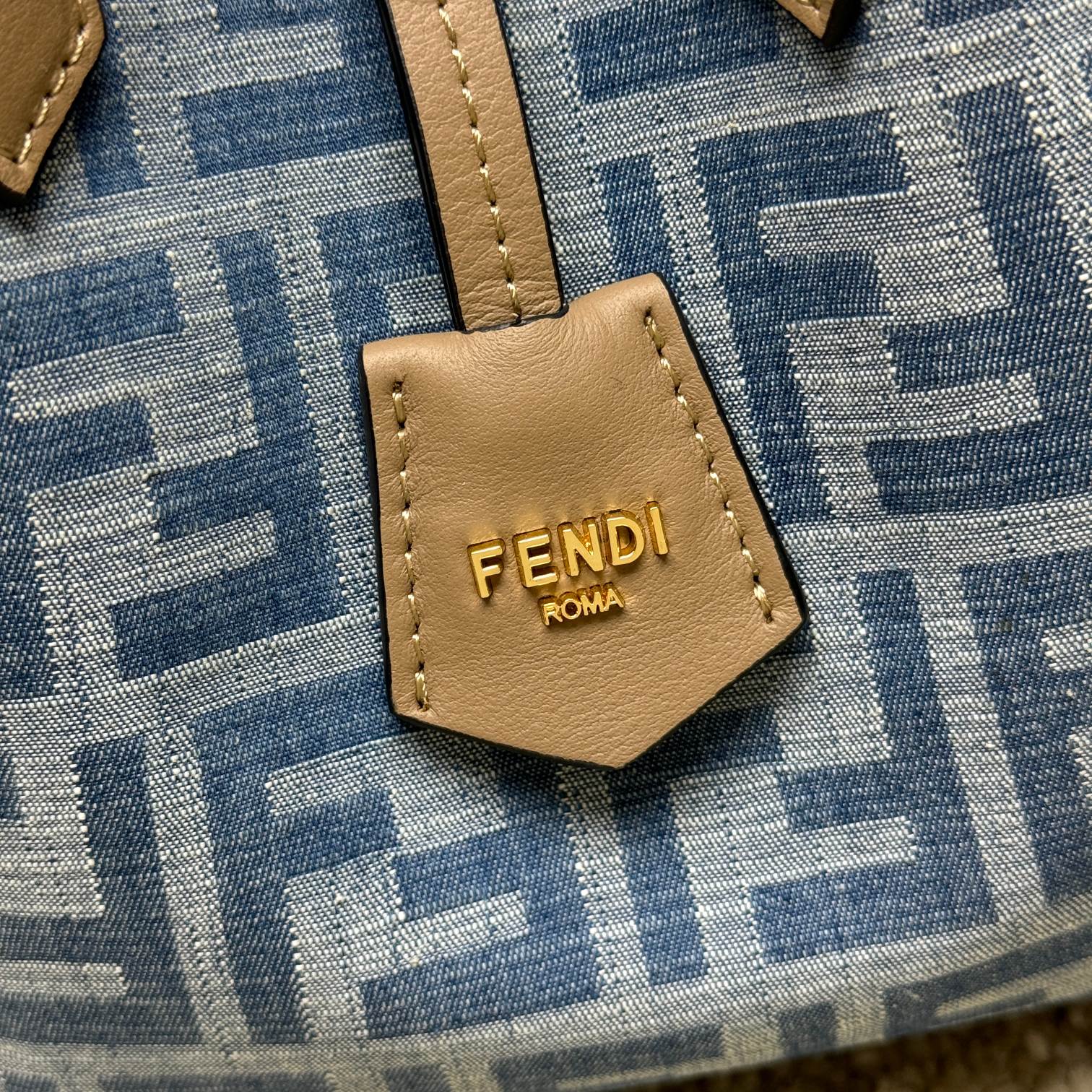 Medium-sized Origami handbag, imitation denim light blue fabric material, decorated with FF pattern. This style is designed with a deformable and innovative design to highlight the double-sidedness and creativity of FENDI: it is equipped with a flexible mechanism composed of 8 magnetic buckles, which can be folded into an origami-style bucket bag. When the magnets are all attracted to the magnetic buckle in the middle, gently pull the leather tie on the short shoulder straps on both sides and turn into a tote bag. It comes with a key ring hanger with metal FENDI lettering and beige leather details. Lined interior compartment with gold finish metal piece. Leather dual handle design for hand or shoulder. Size: 15×15×18.5cm Model: 9918 denim - Image 4