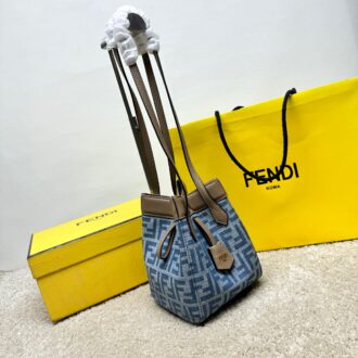 Medium-sized Origami handbag, imitation denim light blue fabric material, decorated with FF pattern. This style is designed with a deformable and innovative design to highlight the double-sidedness and creativity of FENDI: it is equipped with a flexible mechanism composed of 8 magnetic buckles, which can be folded into an origami-style bucket bag. When the magnets are all attracted to the magnetic buckle in the middle, gently pull the leather tie on the short shoulder straps on both sides and turn into a tote bag. It comes with a key ring hanger with metal FENDI lettering and beige leather details. Lined interior compartment with gold finish metal piece. Leather dual handle design for hand or shoulder. Size: 15×15×18.5cm Model: 9918 denim