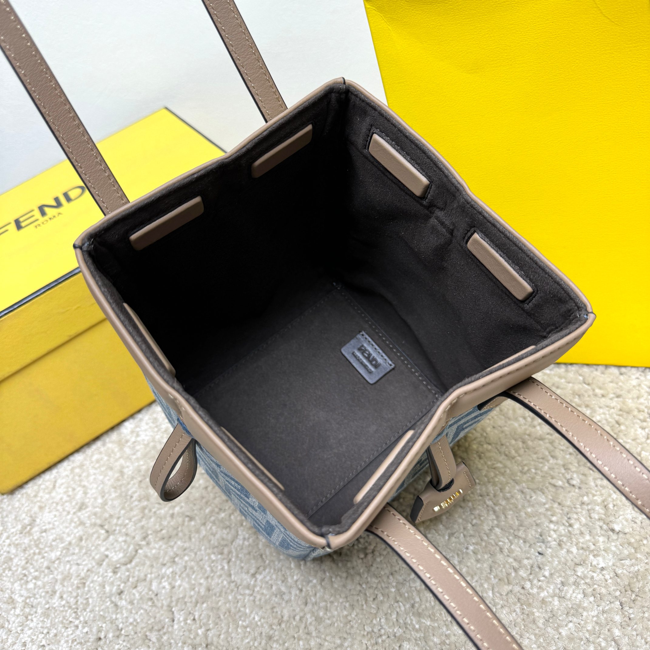 Medium-sized Origami handbag, imitation denim light blue fabric material, decorated with FF pattern. This style is designed with a deformable and innovative design to highlight the double-sidedness and creativity of FENDI: it is equipped with a flexible mechanism composed of 8 magnetic buckles, which can be folded into an origami-style bucket bag. When the magnets are all attracted to the magnetic buckle in the middle, gently pull the leather tie on the short shoulder straps on both sides and turn into a tote bag. It comes with a key ring hanger with metal FENDI lettering and beige leather details. Lined interior compartment with gold finish metal piece. Leather dual handle design for hand or shoulder. Size: 15×15×18.5cm Model: 9918 denim - Image 8