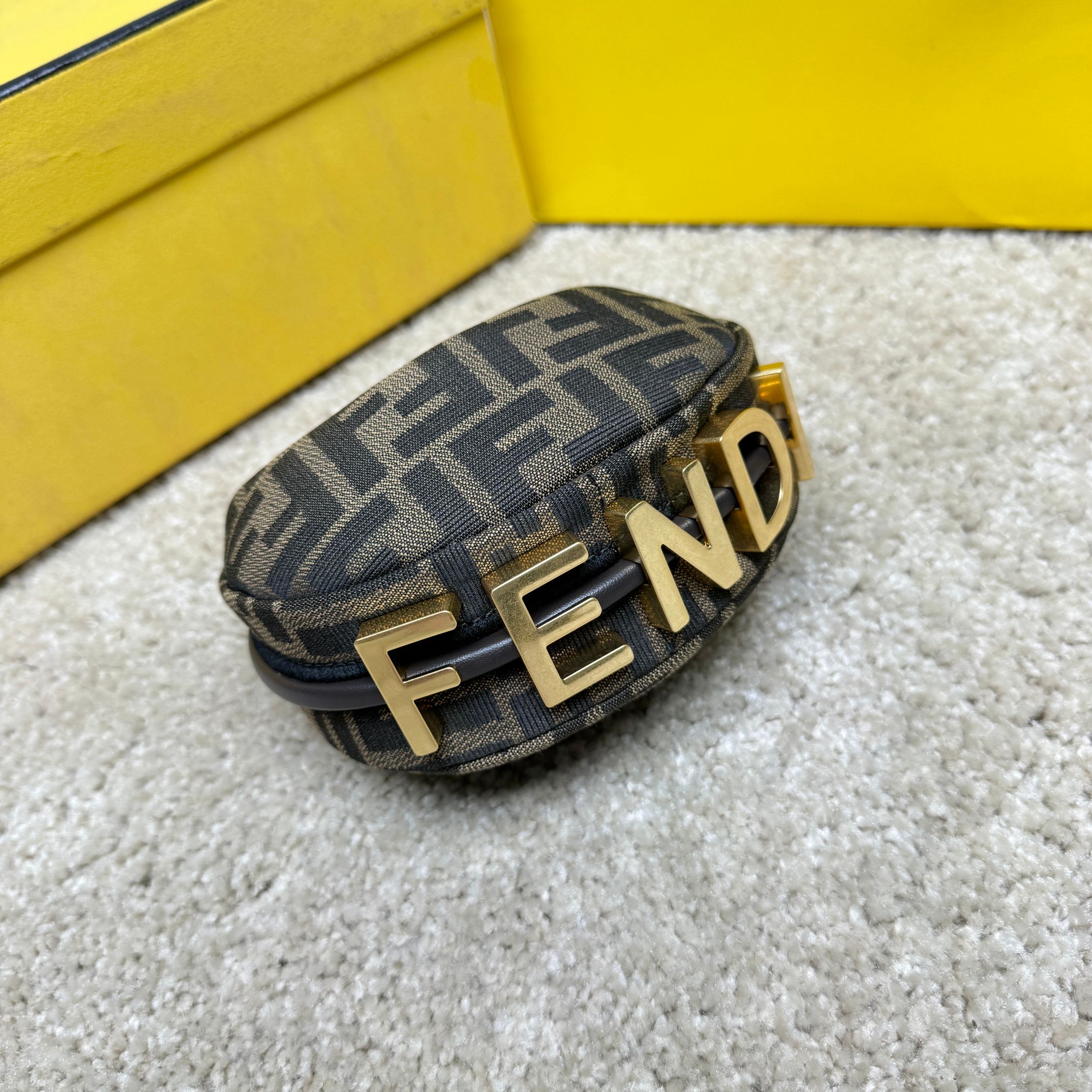 Fendography Nano version of crescent bag, zippered closure, decorated with FENDI retro gold metallic words. It is equipped with adjustable clamp straps, which can be hung on a large bag or worn on the wrist. With shoulder strap hook buckle. Classic FF jacquard fabric material. Brown napa leather details. Gold finish metal parts. Size: 16.5-14-5cm Model: 9933 Old Flower - Image 3