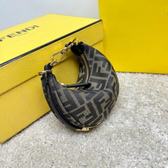 Fendography Nano version of crescent bag, zippered closure, decorated with FENDI retro gold metallic words. It is equipped with adjustable clamp straps, which can be hung on a large bag or worn on the wrist. With shoulder strap hook buckle. Classic FF jacquard fabric material. Brown napa leather details. Gold finish metal parts. Size: 16.5-14-5cm Model: 9933 Old Flower