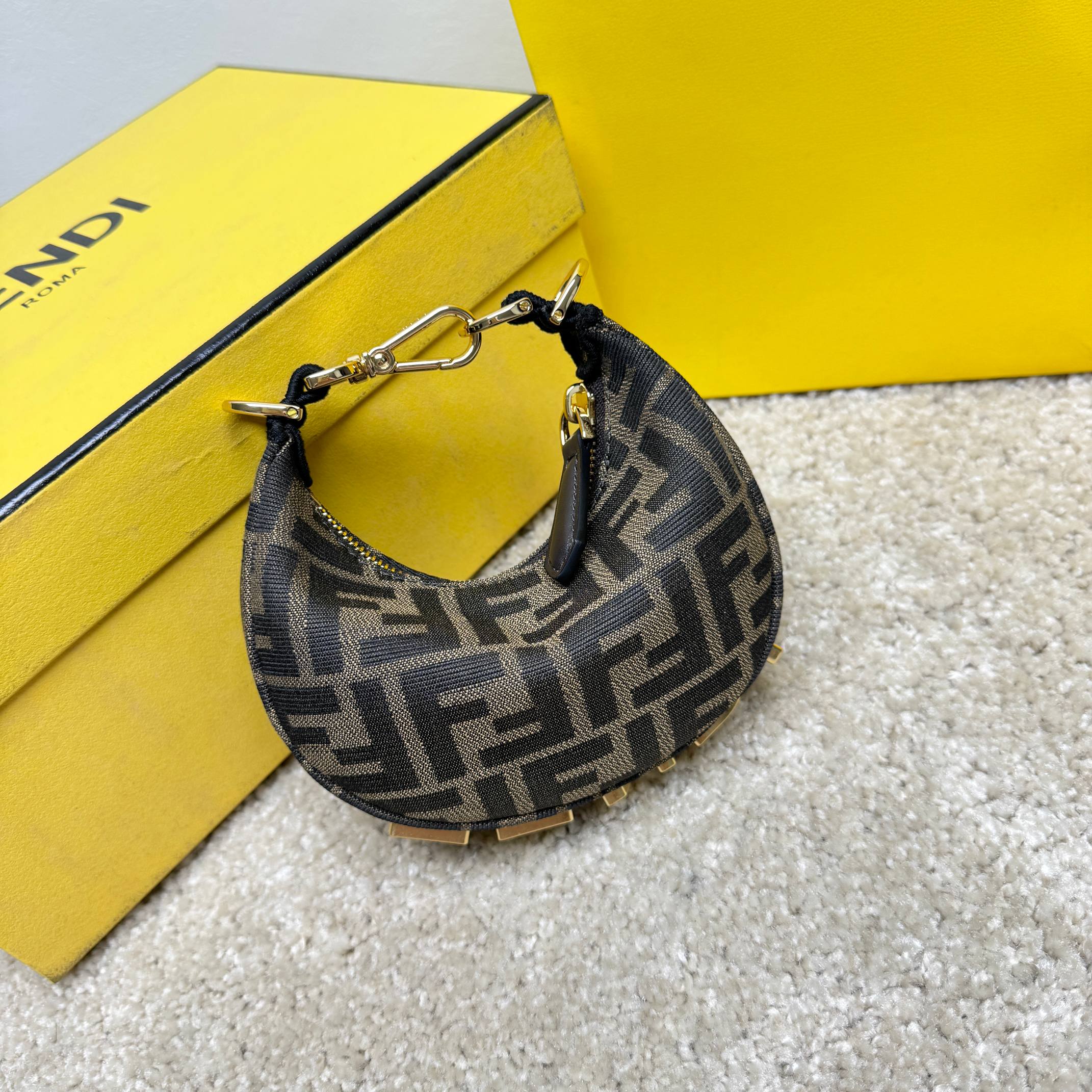 Fendography Nano version of crescent bag, zippered closure, decorated with FENDI retro gold metallic words. It is equipped with adjustable clamp straps, which can be hung on a large bag or worn on the wrist. With shoulder strap hook buckle. Classic FF jacquard fabric material. Brown napa leather details. Gold finish metal parts. Size: 16.5-14-5cm Model: 9933 Old Flower - Image 2