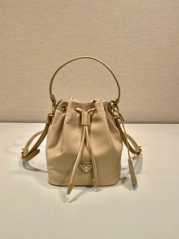 Pjia Fat Bag 1BE067✨✨ This bucket bag is made of imported nylon fabric, top-grade gold hardware, and logo lining. It is equipped with a long detachable and adjustable cowhide shoulder strap, drawstring opening and closing, and the weight is super light. Size: 19.5 x 15.5 x 10