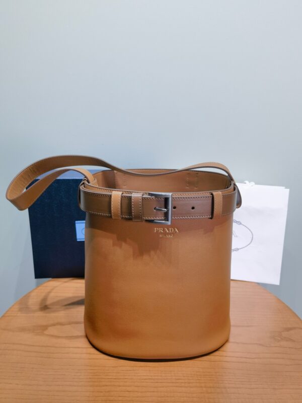 New Prada Buckle belt bucket bag fashion show ✅1BE085 Explain the Prada Buckle handbag with a new style of fashionable bucket bags, revealing the true meaning of modern and exquisite. With buckle decorative straps, the finishing touch of the modern versatile design. Embossed letter logo at front, calfskin ✔️Nappa sheepskin inner lining, with patch pockets. The shoulder straps are adjustable in length✔️. Removable buckle leather strap, can also be used as a belt Size: width 26.5x height 29x bottom 18cm