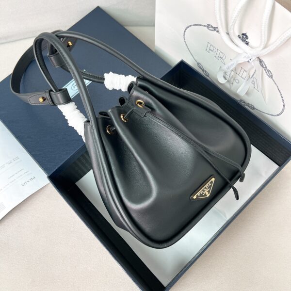 ✨New product first launch✨New product Darling Elf Ear Bucket Bag 1BE087 uses chic and noble calfskin. The elegant and simple body design has smooth and elegant lines. Classic logo on the front, golden triangle logo, drawstring opening and closing, long handle can be carried and underarm back. The inner bag is spacious and has patch pockets to meet the needs of exquisite storage. Perfect details are comparable to the brick cabinet. Super great. 5🌟 size: 22*21*10.5cm. Black