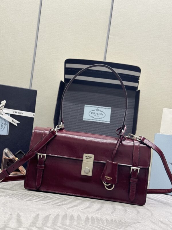 25SS spring and summer new style 🎉 Amaranth Red Pen Pack 🎉 1BN026 small size arrived 🎉🎉🎉, this leather handbag is inspired by a crisp and formal briefcase, with a delicate and shiny texture, reinterpreting the classic office style silhouette with a new attitude. The exquisite and soft detail design adds gentle and versatile charm to the classic look of the bag. The classic vertical locking buckle is decorated with details, and it is paired with a long hand handle, which can be carried on the shoulder, making it more practical. Another permanently outdated hit model, hurry up and buy it 🎉🎉 Size: 32 long and 16.5x bottom 10cm (This handle is long and does not match the packaging)